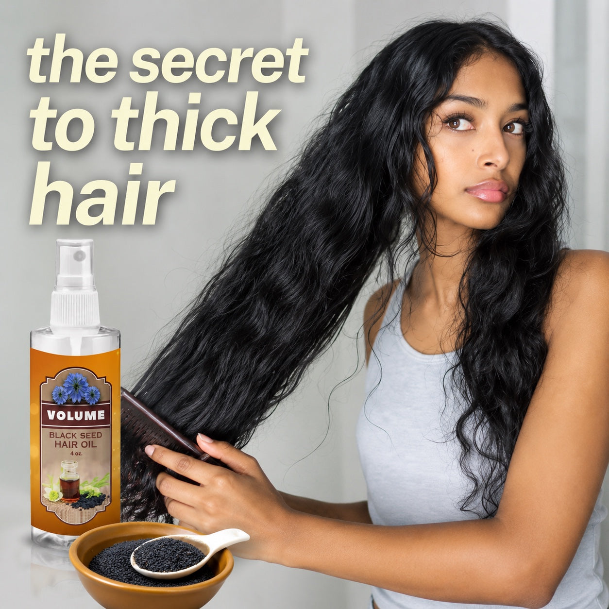 Woman combing long thick hair beside a 4oz bottle of Volume Black Seed Hair Oil and a bowl of black seeds — the secret to thick hair.